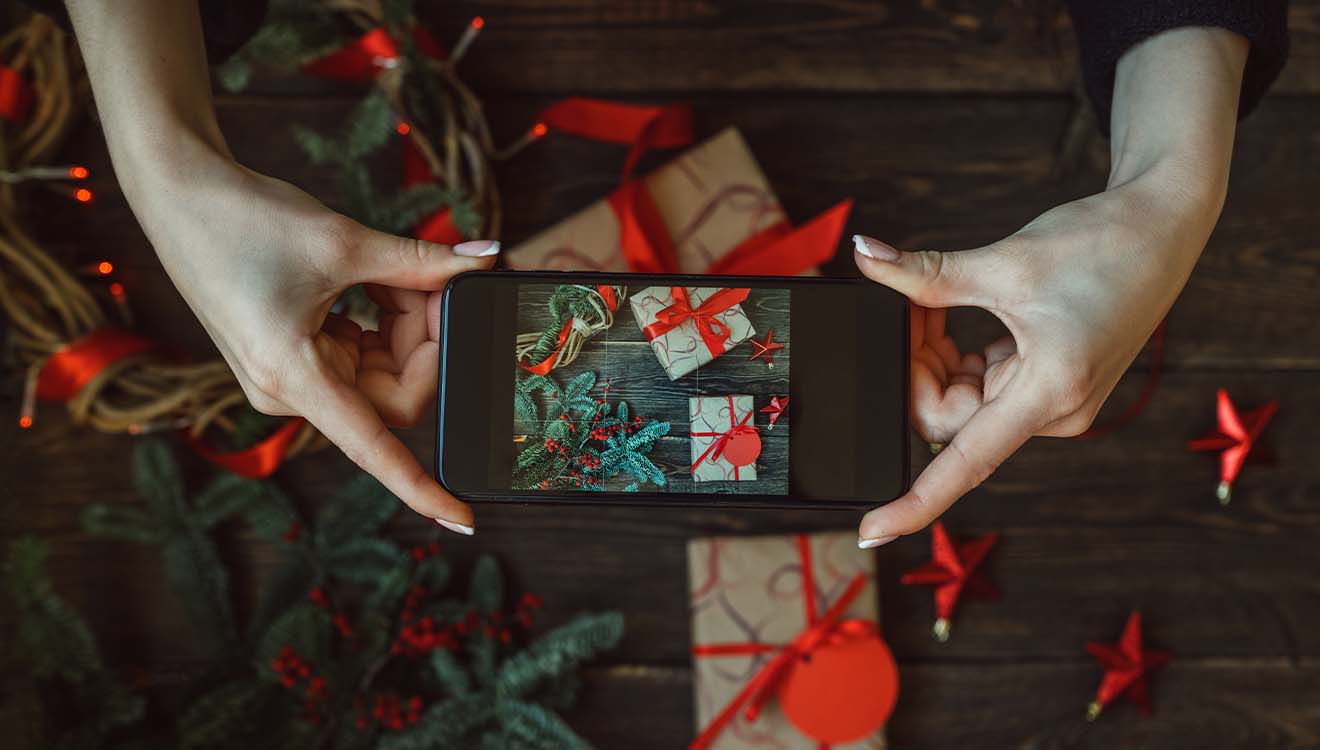 Kvinde tager billeder af gaver med smartphone